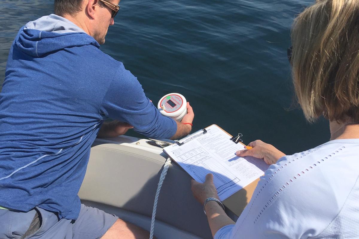 Water monitoring volunteers Dave Chappell and Joanne Akie work together to measure and record water temperature in Wolfeboro Bay